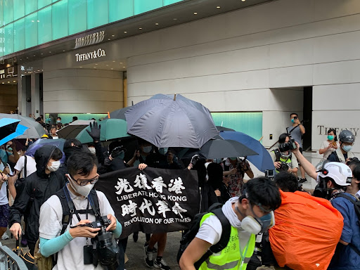 Protestors in Hong Kong showing a flag with the slogan.