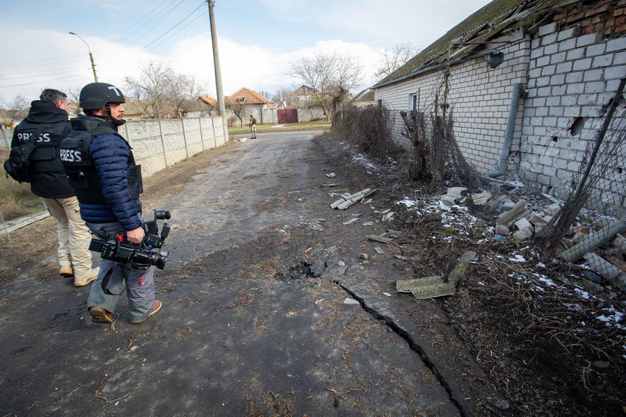 A television news team examines the result of a Russian missile strike in a residential neighborhood in the port city of Mykolaiv, Ukraine, on March 9, 2022.