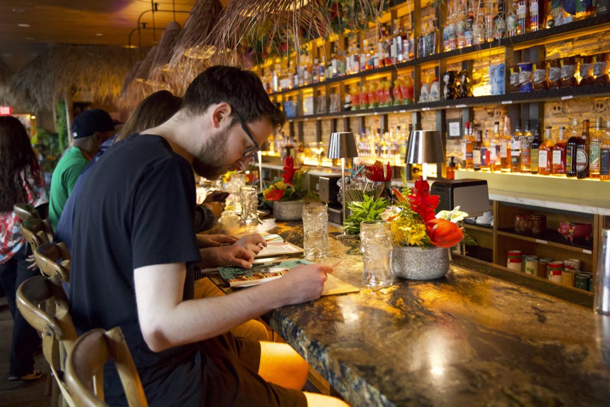 Customers at the Wusong Tiki Bar check out the restaurant menu carefully.
